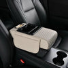 A beige car armrest cushion with integrated cupholders and storage is shown in a black car interior.