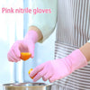 A hand wearing pink nitrile gloves is holding an orange piece over a metal bowl.