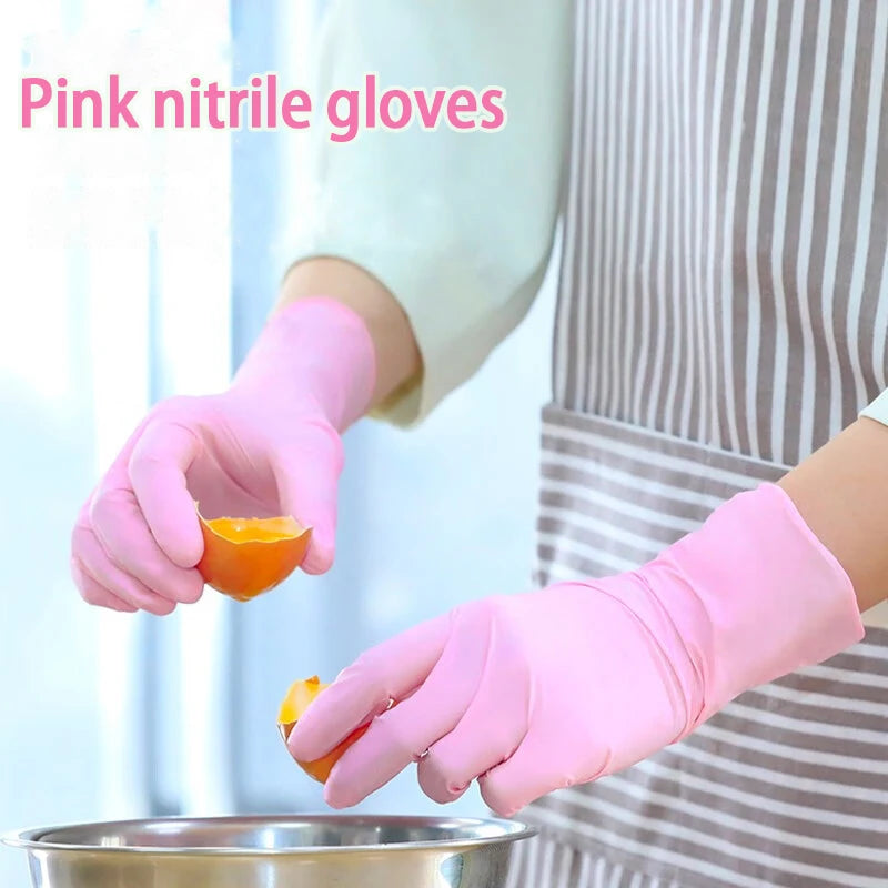 A hand wearing pink nitrile gloves is holding an orange piece over a metal bowl.