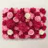 A dense wall panel of pink and deep red silk rose flowers for weddings and events.