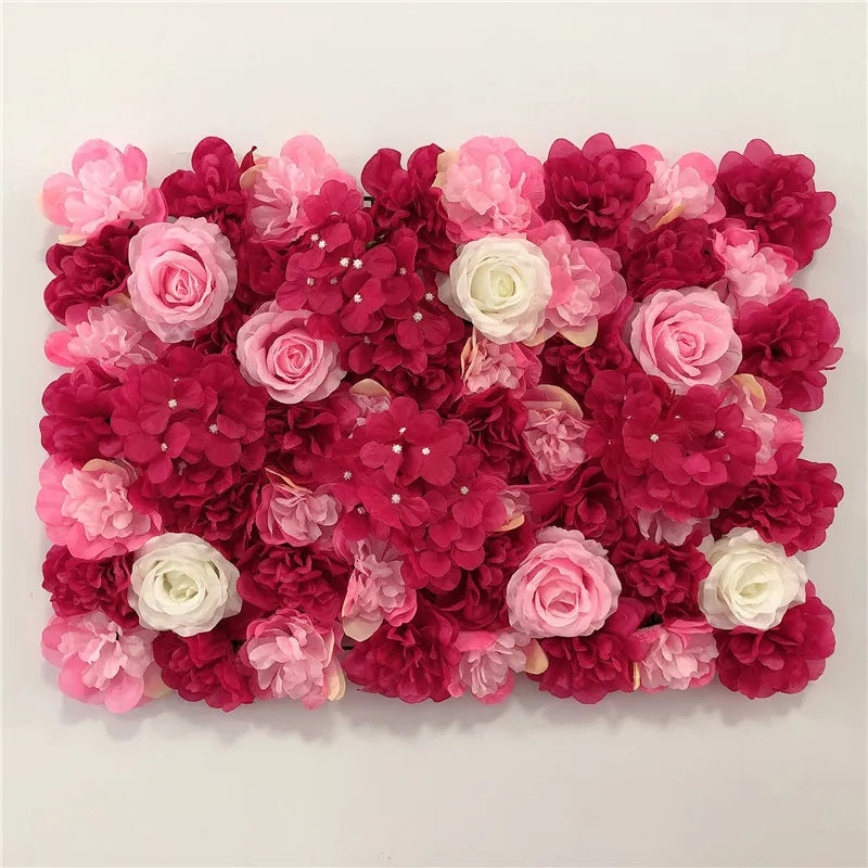 A dense wall panel of pink and deep red silk rose flowers for weddings and events.