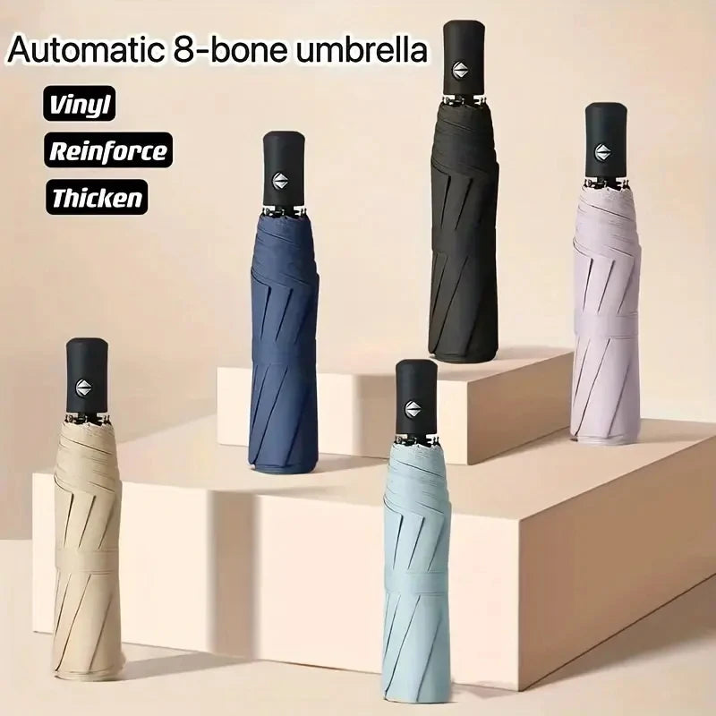 A set of automatic 8-bone umbrellas in various colors, including black, gray, and light blue, displayed on a white pedestal.