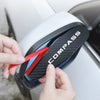 A hand is inserting a red strip into the compass logo on a white vehicle's side mirror.