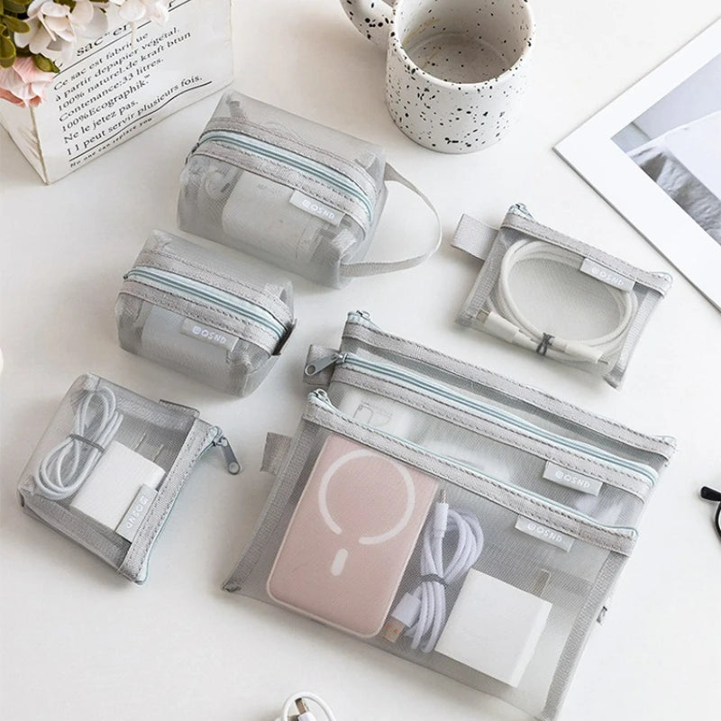 A collection of transparent mesh storage bags with zippers, including coin and card organizers, arranged on a white surface.