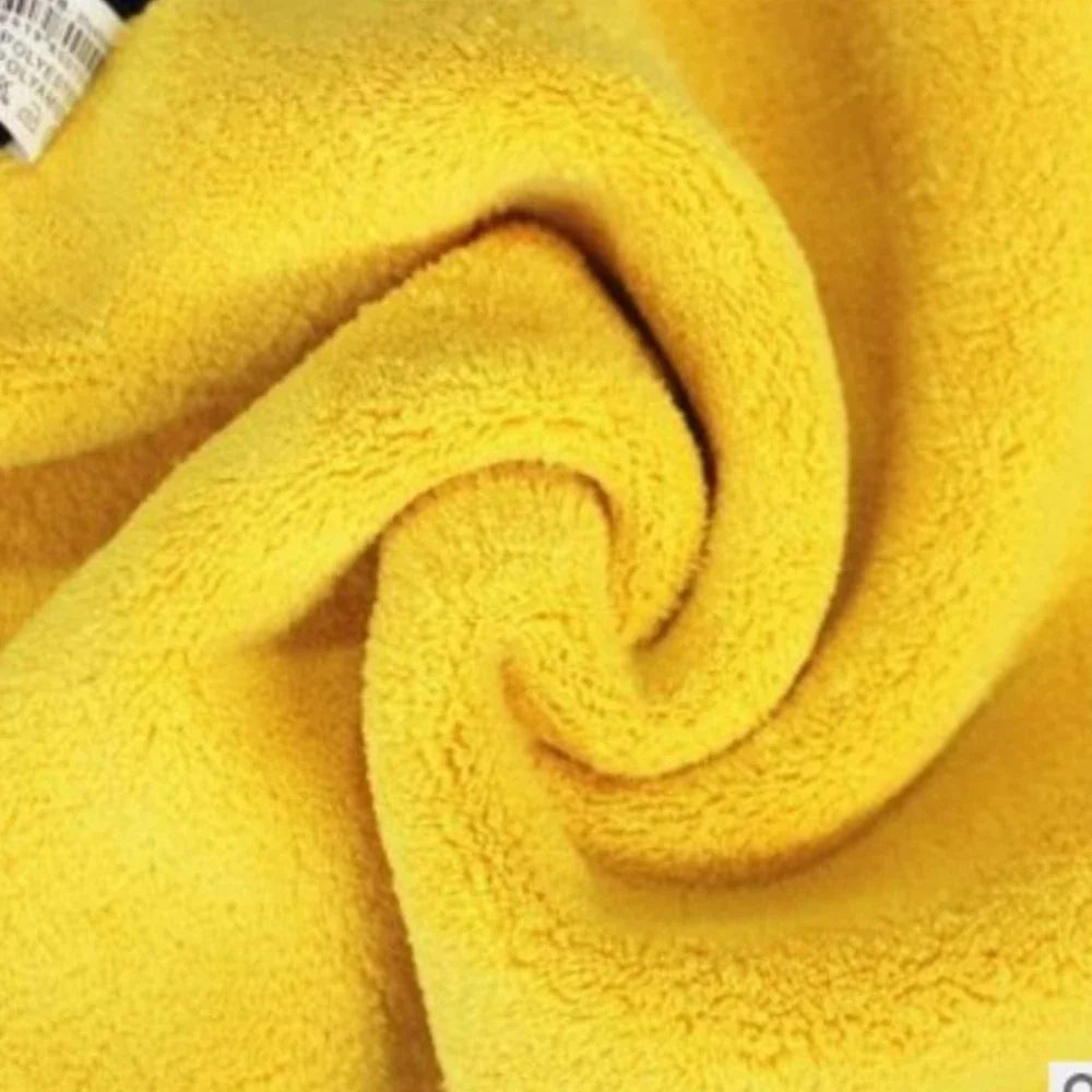A close-up of a bright yellow microfiber car cleaning towel rolled into a swirl.