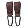 A pair of dark brown PU leather stroller hooks with black grips for organizing baby bags.