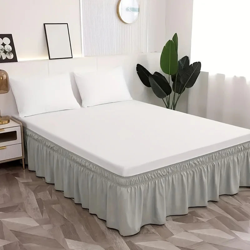 Un lit blanc avec une jupe élastique gris poussiéreux et décoration moderne.