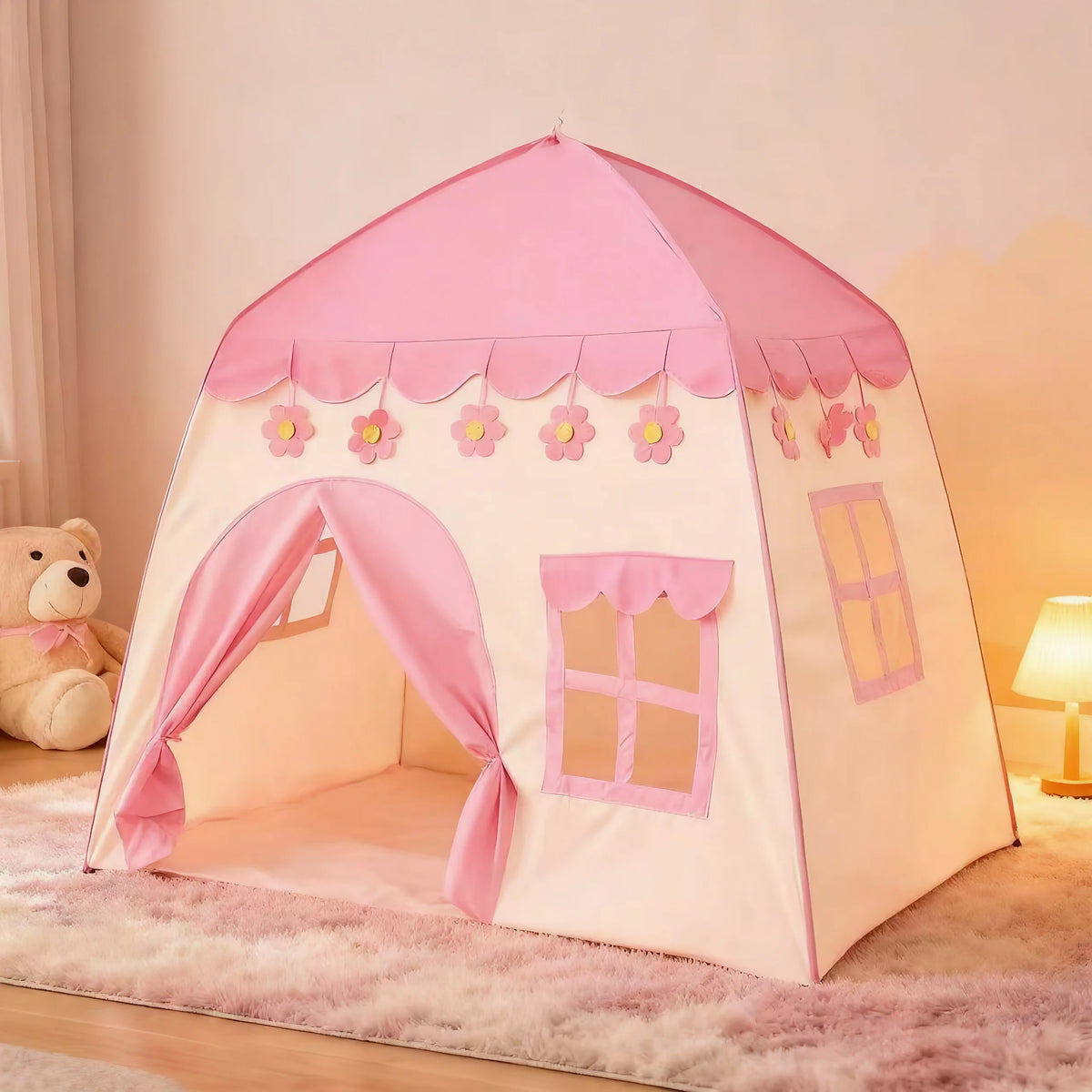 A pink flower playhouse tent for kids with scalloped trim and window details set up indoors.