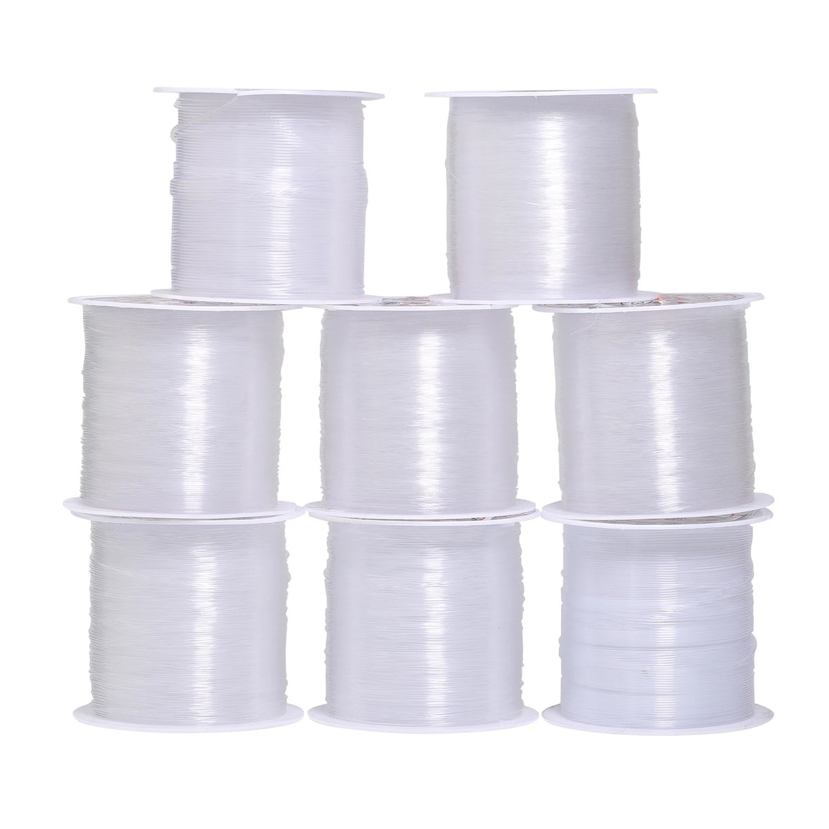A collection of white nylon beading cord spools in various sizes and rolls.
