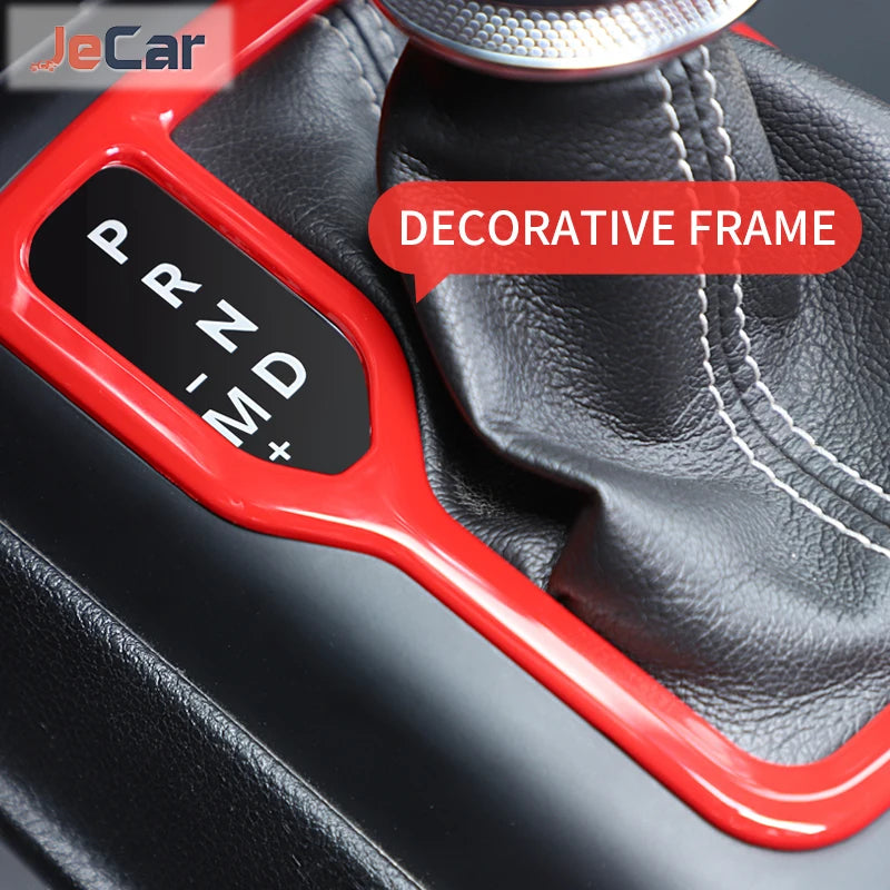 Red decorative frame trim cover for an ABS gear shift panel and cup holder on a Jeep Wrangler or Gladiator.
