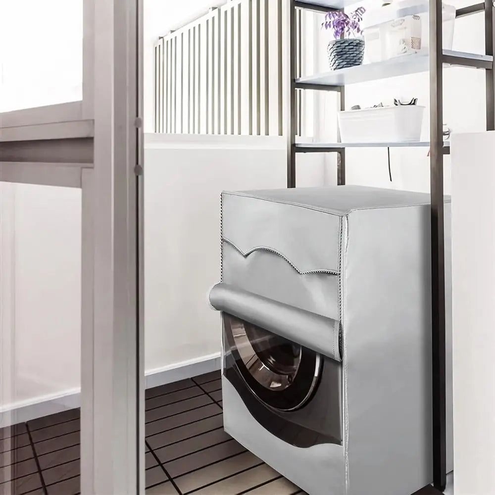 A silver waterproof washing machine cover with a roll edge design is shown inside a modern bathroom or laundry area.