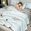 A light blue ultra-soft comforter with embroidered words and a butterfly design is displayed on a bed.