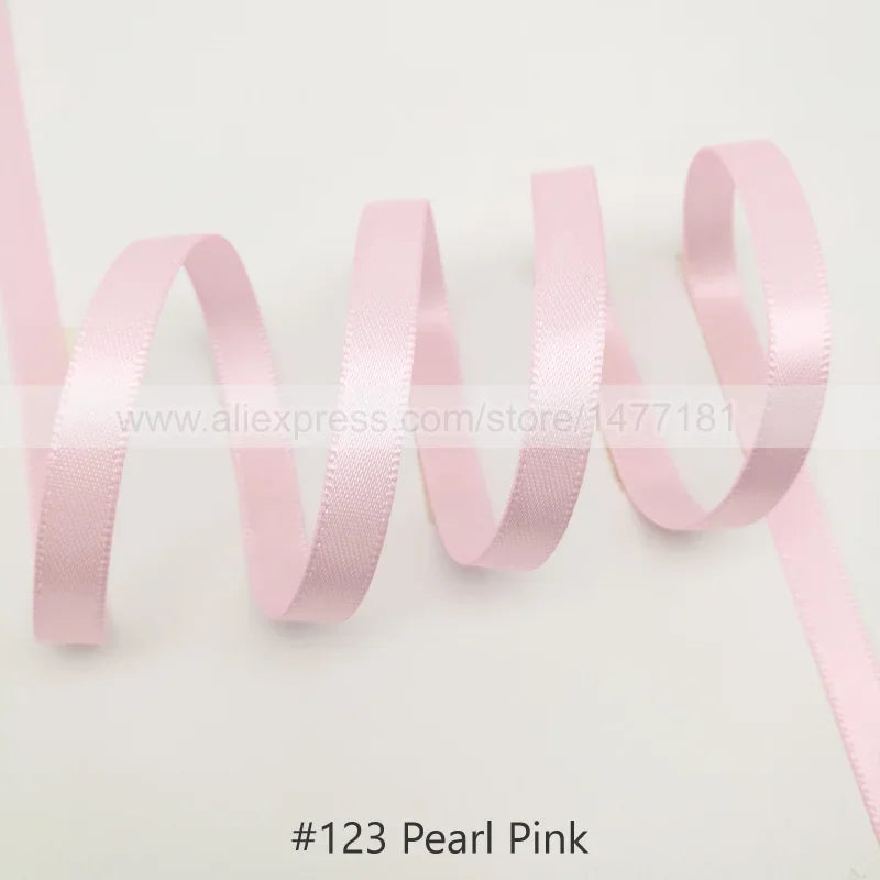 Pink satin ribbon in pearl pink color shown in a wavy line pattern