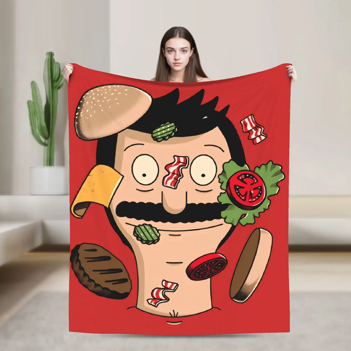 A red throw blanket featuring a playful cartoon illustration of a man with a mustache and a burger.