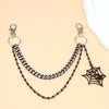 Silver metal chain strap with a black spider charm displayed on a beige background