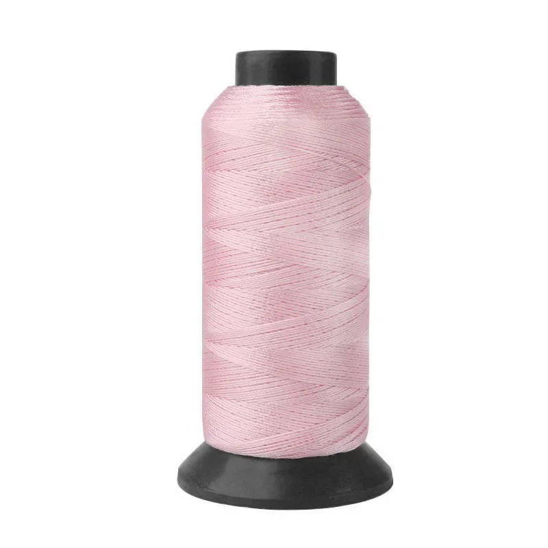 A spool of pink heavy-duty nylon sewing thread for upholstery and denim.
