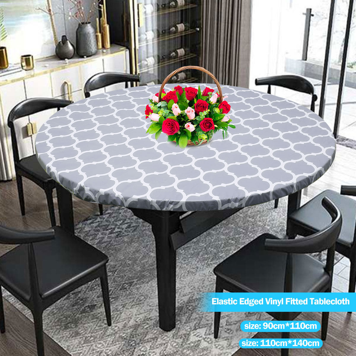 A round table set featuring a gray patterned elastic-edged vinyl tablecloth and black dining chairs.