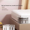 A white bed sheet fastener clip is shown resting on a wooden surface next to a bed frame.