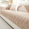 Funda de cojín beige texturizado con almohadas blancas y una taza blanca en una cama blanca.