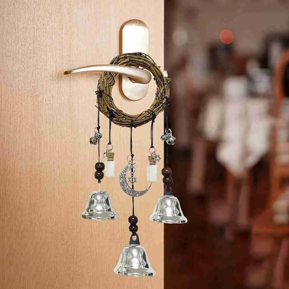 A decorative witch bells door hanger wind chime made of natural twine and glass hanging on a wooden door.