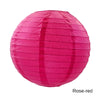 A round, pink paper lantern with vertical folds, colored rose-red.
