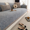 Hellblaue strukturierte Sofabezug mit beige Kissen und dekorative Katzenform-Kissen auf einem modernen Wohnzimmersofa.