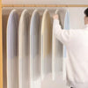A person is hanging transparent zippered garment storage bags on a wooden rod.