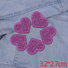A set of five purple glitter heart iron-on embroidered patches on a denim fabric.