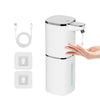 A white touchless infrared smart soap dispenser with a pump dispenser and USB charging cable is shown next to a hand.