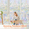 A woman is petting a golden dog in front of a window decorated with a stunning rainbow stained glass effect film.
