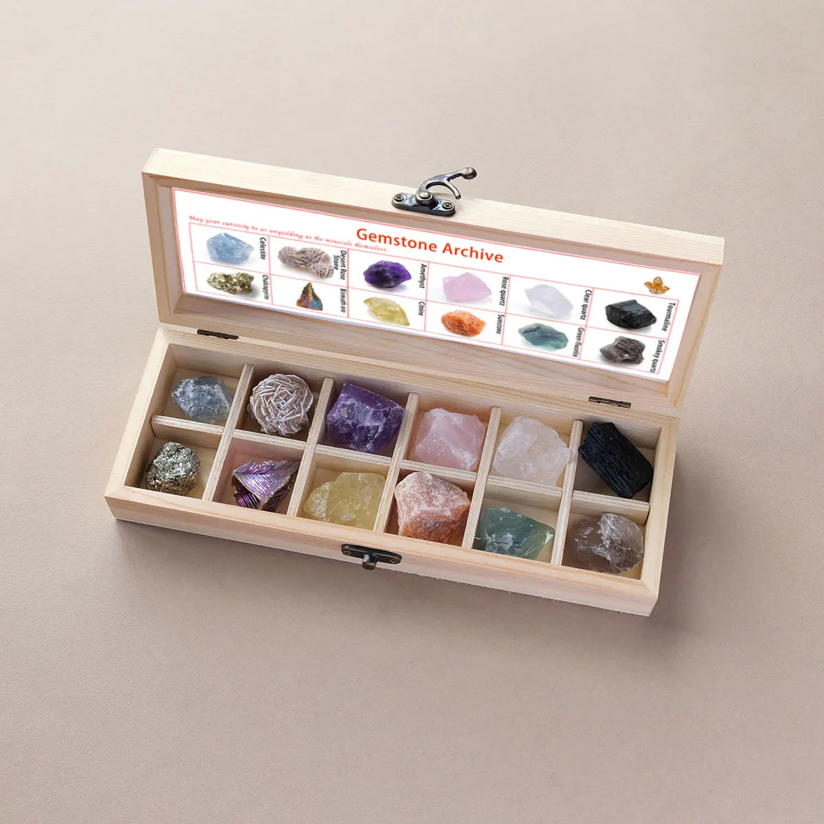 A wooden gift box containing twelve natural gemstone crystals arranged in compartments with an informational label.