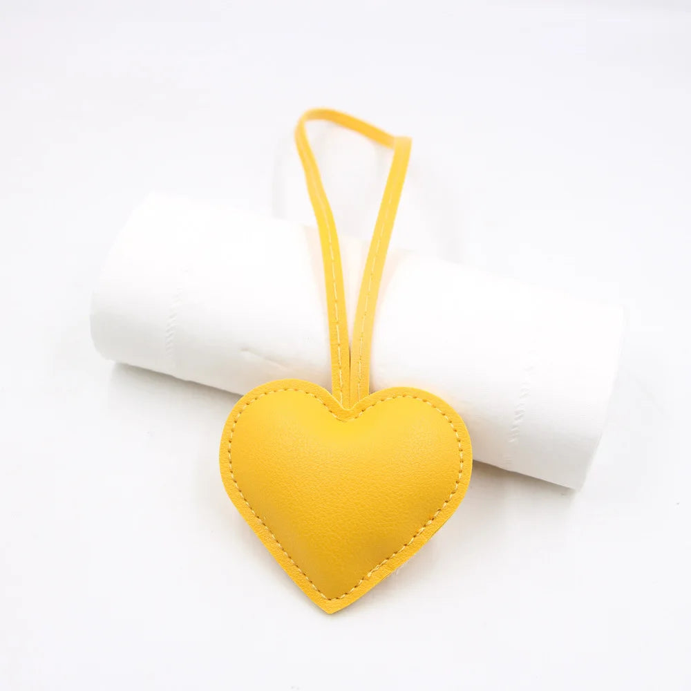 Yellow heart-shaped PU leather keychain with a cotton peach charm