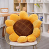 A sunflower shaped floor pillow in yellow and brown fabric sitting on a gold wire chair.