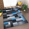 Abstract geometric anti-slip area rug featuring shades of gray black and blue on a wooden floor.