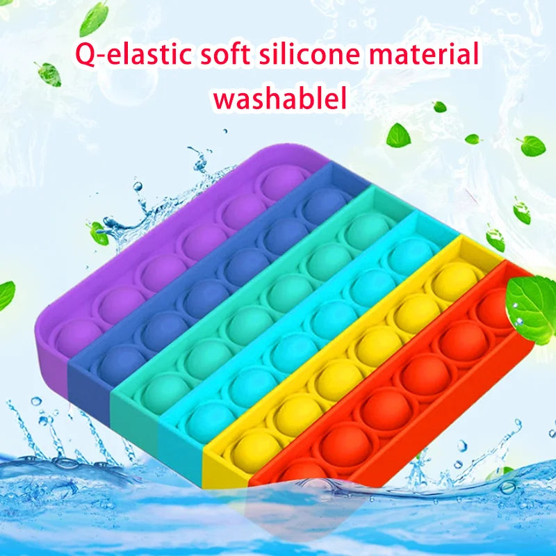 Rainbow colored silicone bubble fidget toy arranged in a diagonal stack on water