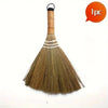 A natural grass broom with a wooden handle and white bristles is shown against a white background.