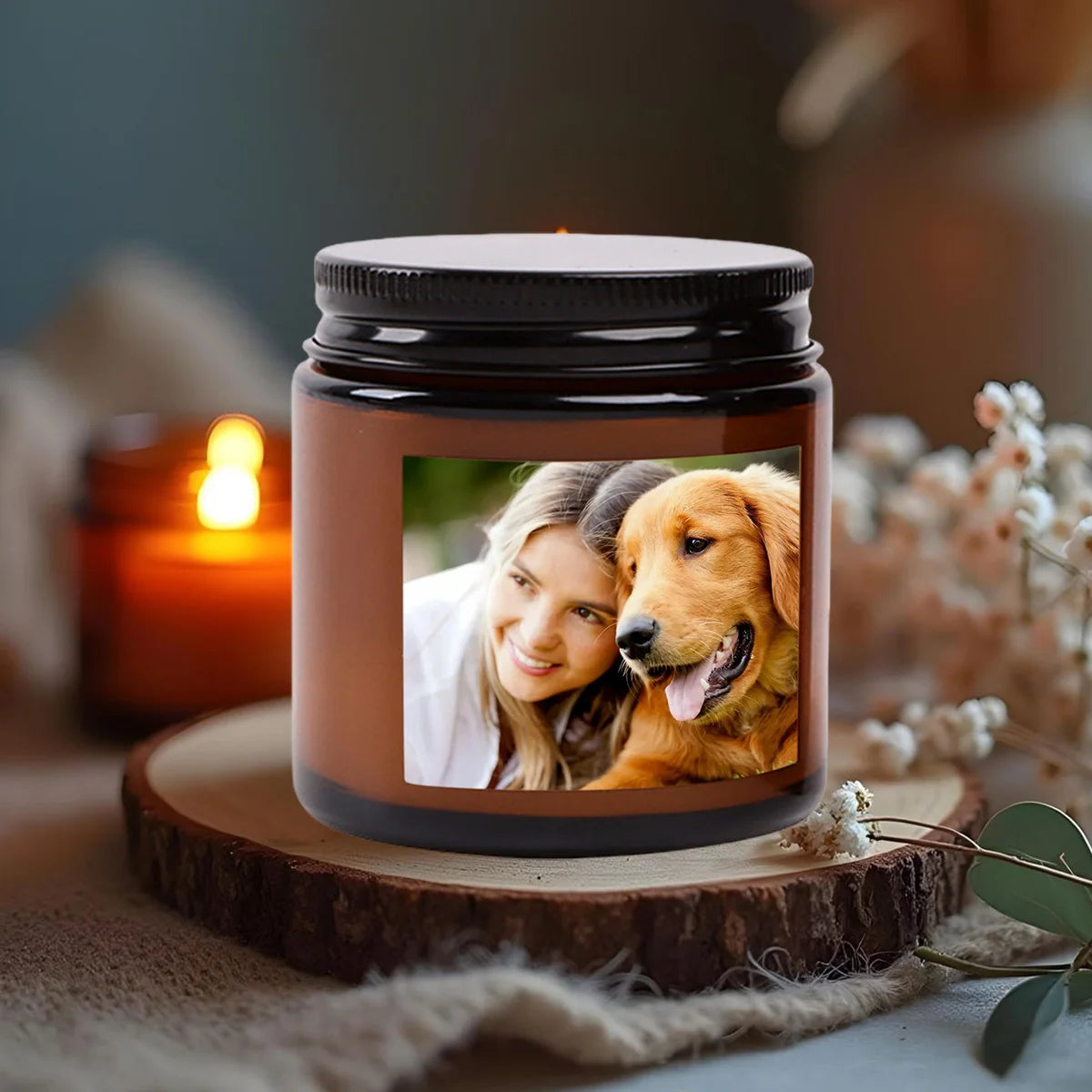 A personalized photo scented soy candle in a dark glass jar resting on a wooden slice.