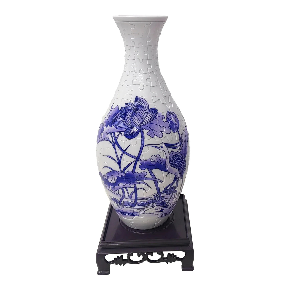 White ceramic vase with blue floral patterns and a puzzle texture displayed on a dark stand.