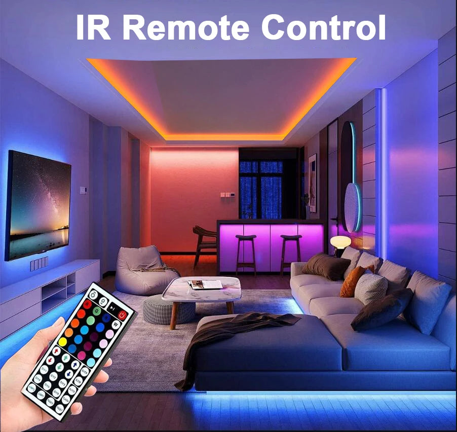 A hand holds an IR remote control for a smart app-controlled RGB LED strip light system in a modern living room.