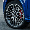 Close-up of a blue Audi wheel with black and silver decorative alloy rims and a red brake caliper.