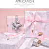 Pink satin ribbon rolls and gift packaging with silver ribbons displayed on a white marble surface.