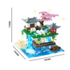 A micro building block set depicting a pink sakura treehouse with a traditional Japanese-style roof and water features.