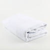 White fleece throw blanket folded neatly on a white surface.