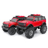 Red RC truck with black body and tires, featuring rubber mud terrain tires for Axial SCX24 & TRX4M.
