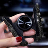 A hand holds a black crystal air vent car phone holder with a textured finish.