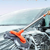 An orange double-headed extendable mop is shown washing water off a black car's windshield.