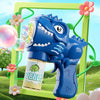 A blue dinosaur bubble gun with lights and a soap blower is shown in a green frame against a grassy background.