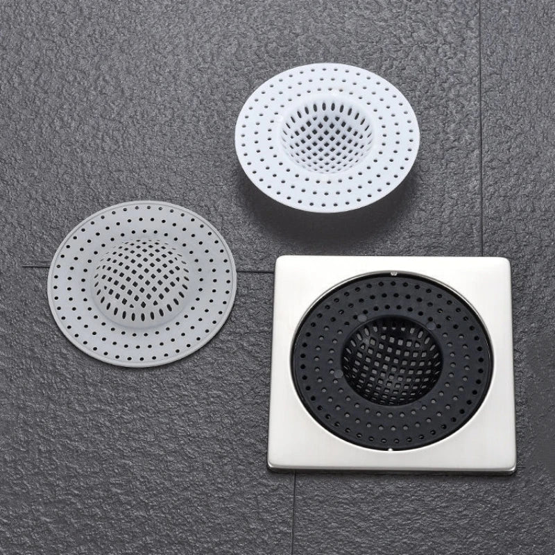 Three circular silicone sink drain filters or strainers are displayed on a dark gray surface.