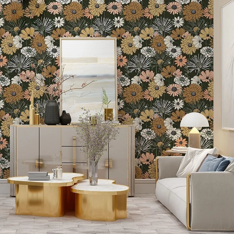 A room decorated with a dark green and white floral wallpaper, gold accents, and light wood furniture.