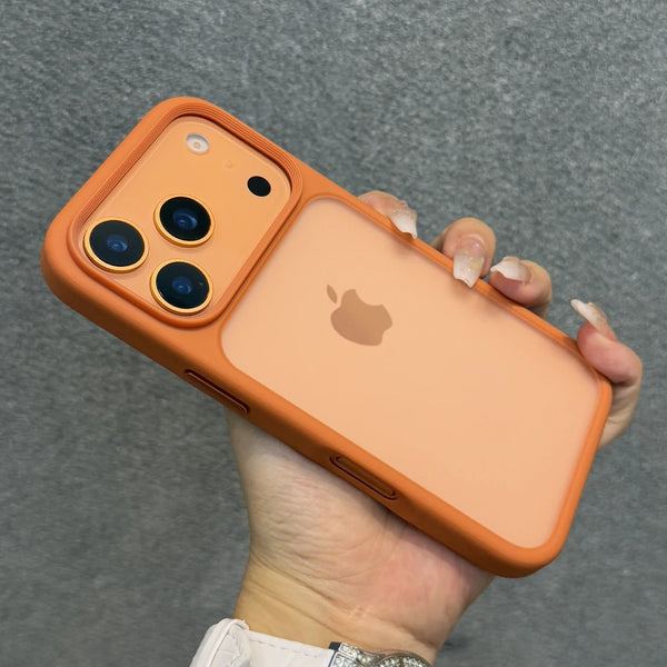 Una mano sostiene una funda de teléfono con acento naranja y parte trasera transparente mate, mostrando el módulo de la cámar